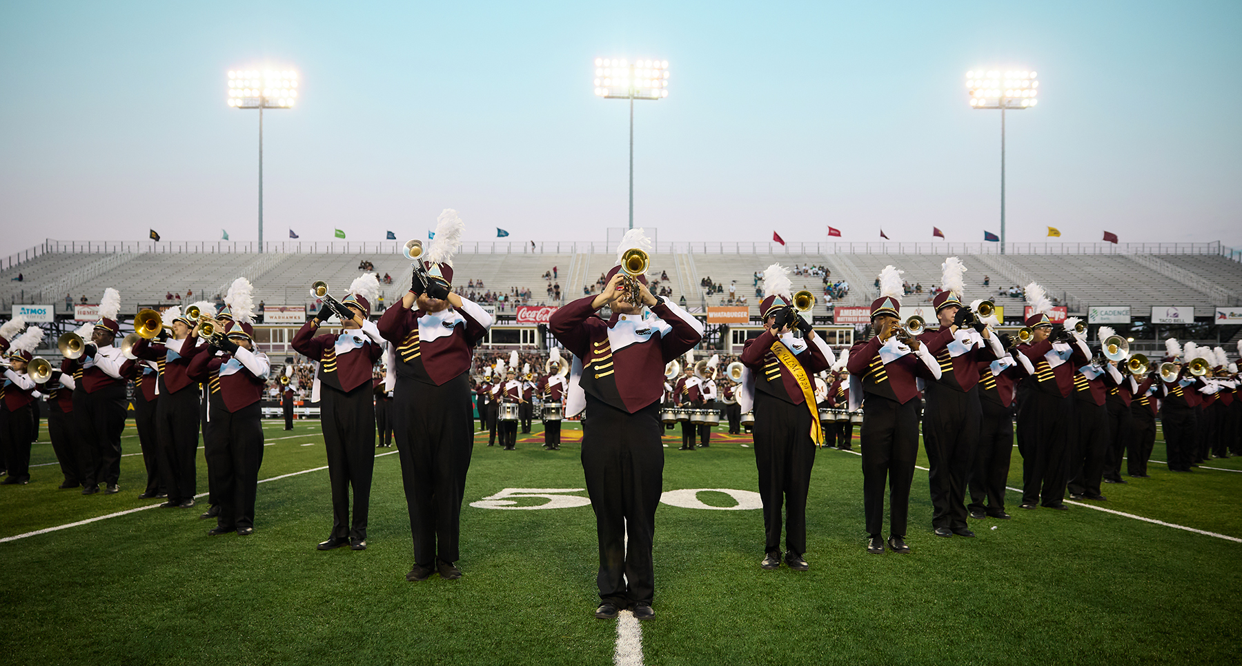 A marching band plays at the 50-yard line