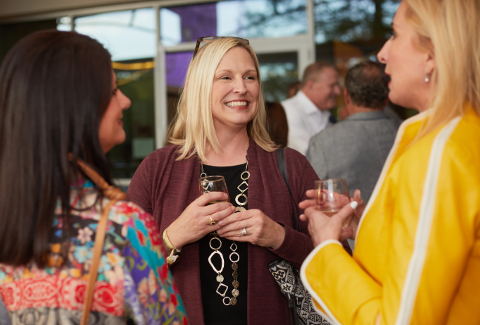 women laughing at wine over water