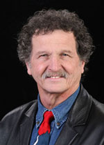 Professor Emeritus Gary Ratcliff is wearing a black jacket, blue shirt, and is smiling.