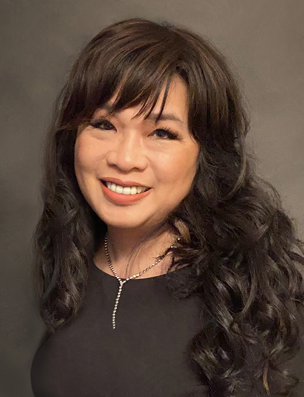 Winnie Tomeny has black hair and is wearing a black shirt and smiling.