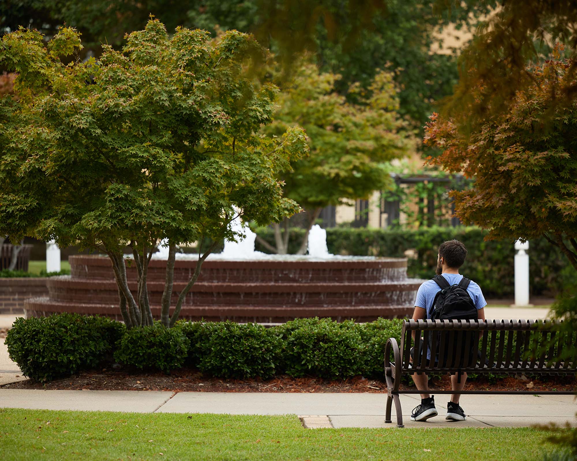 student sitting in front of fountain