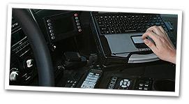 hands on computer in police vehicle