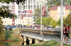 students walking across bridge of bayou