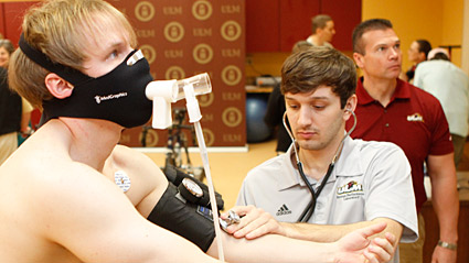 student monitoring athlete in lab