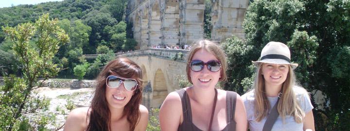 three students smiling at Pont du Gard