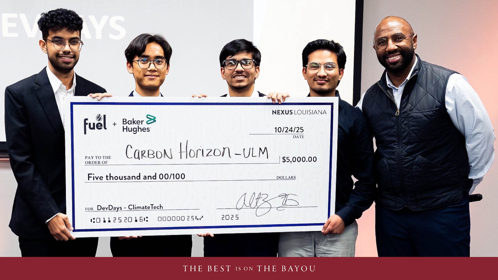 Five people smiling while holding a large check. 