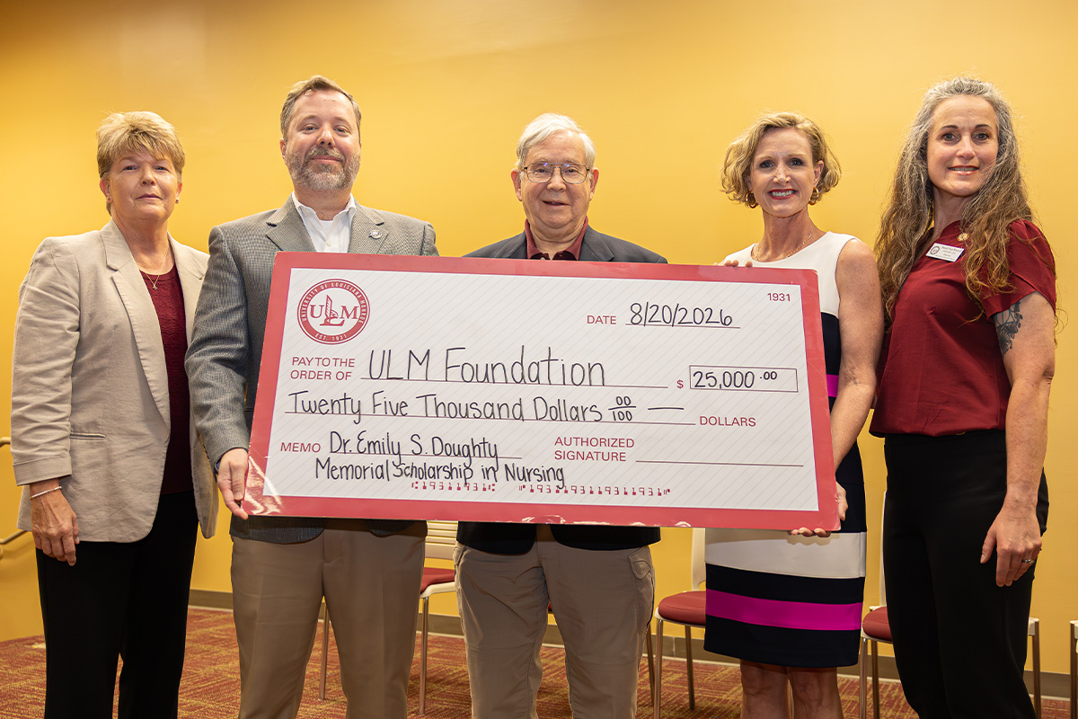 A group of people stand with a large check.