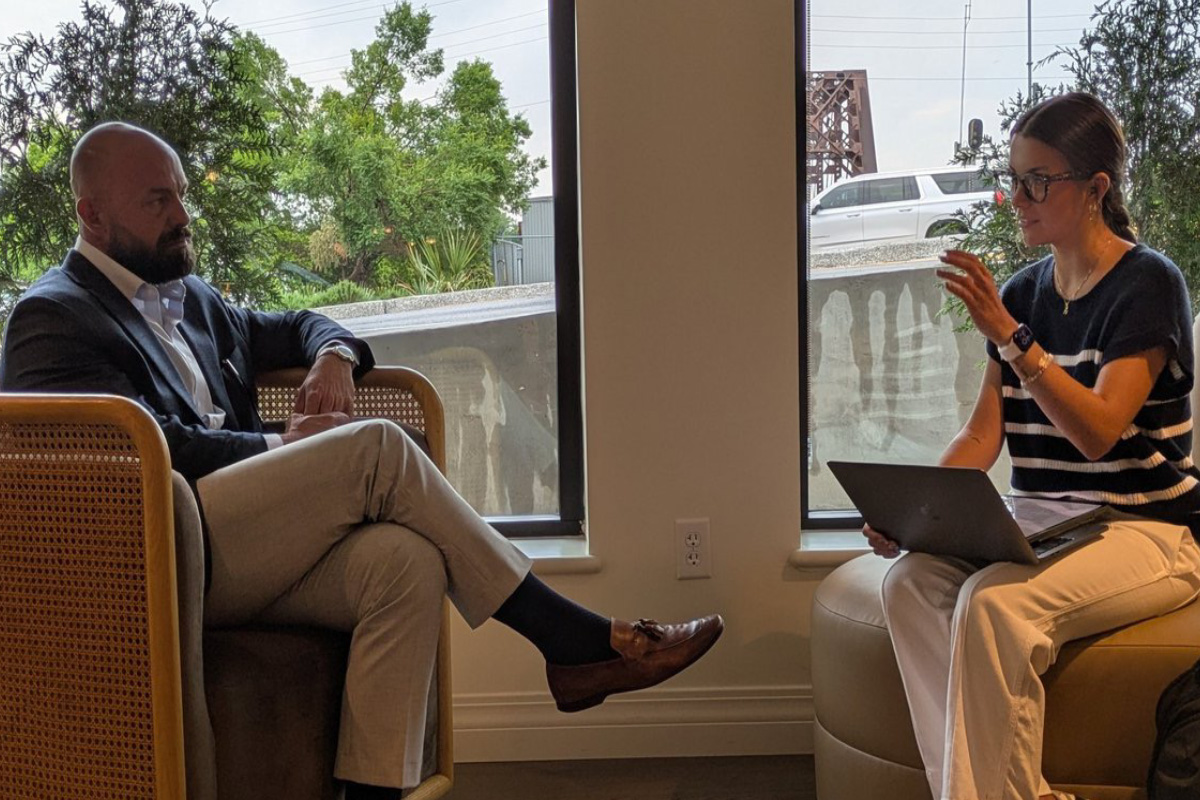 Monroe Mayor Friday Ellis discusses the results of a survey with ULM student Catalina Droddy as they sit in chairs. 