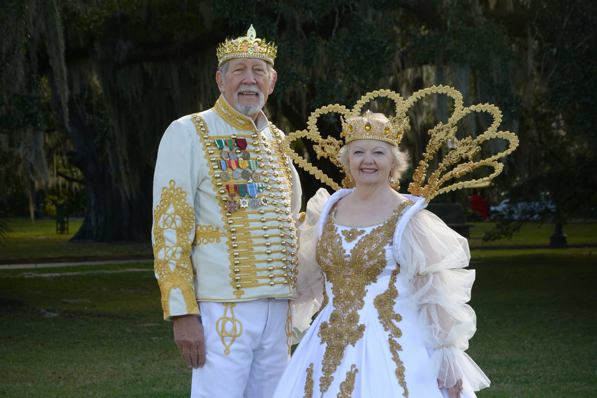 A man and woman dressed in Mardi Gras royalty clothing.