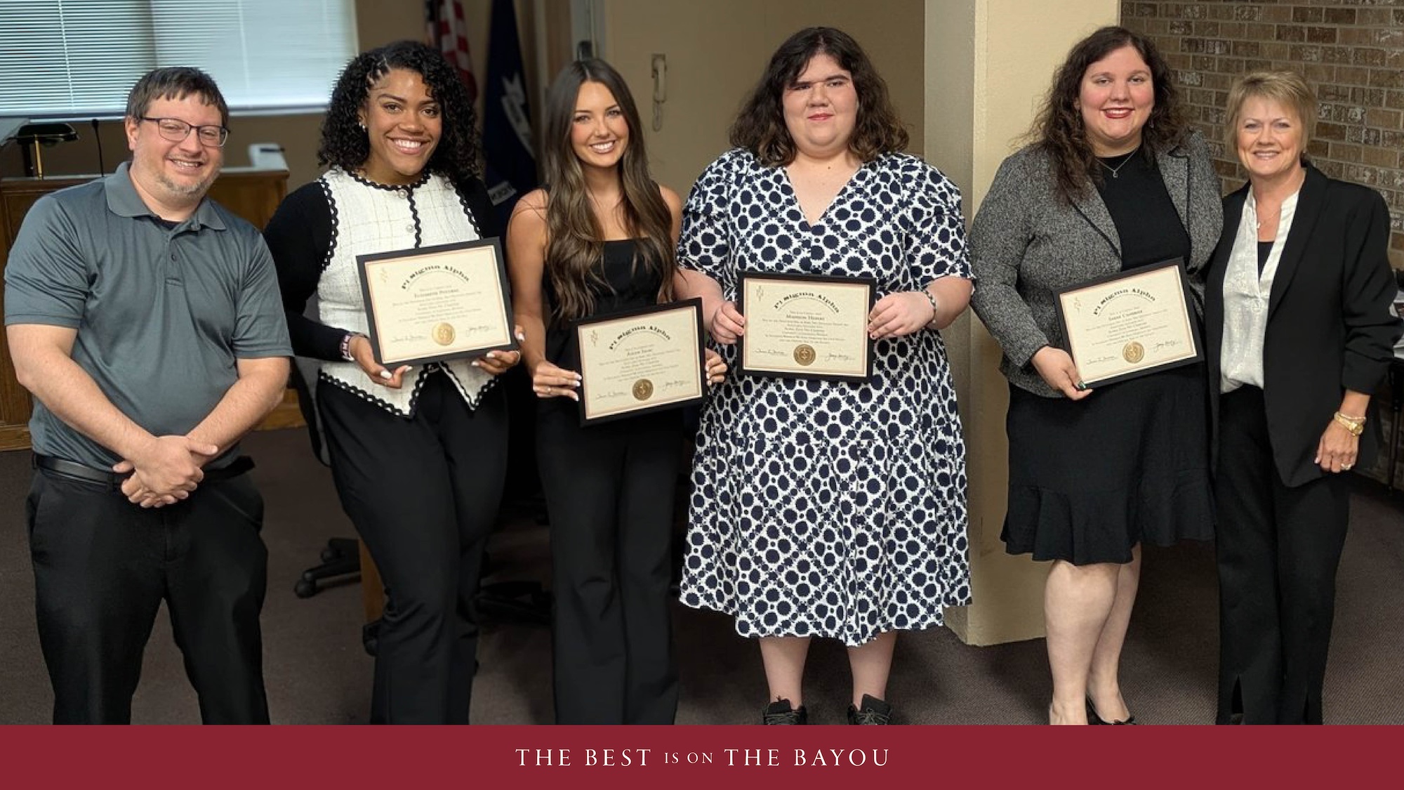 A group of inductees into the Pi Sigma Alpha honor society pose and smile after their induction. 