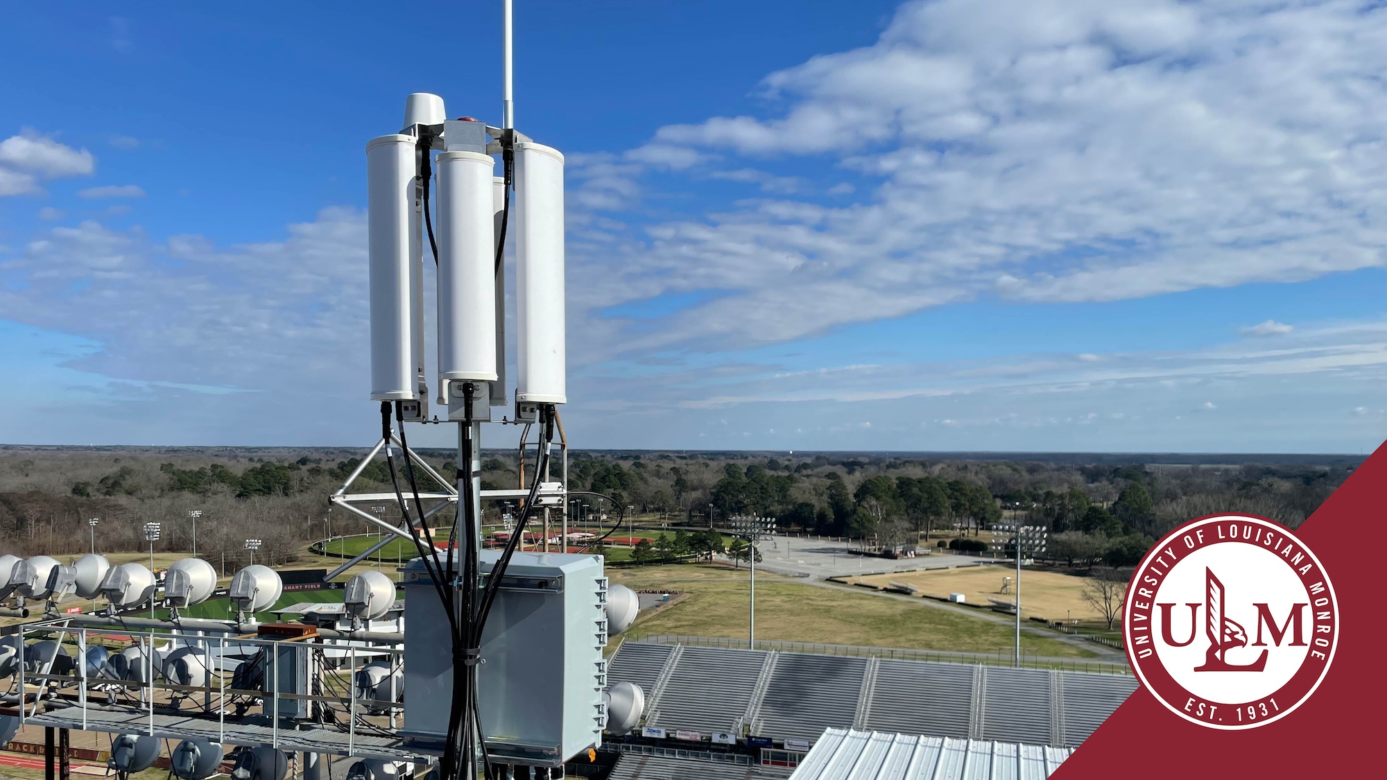 Drone detection equipment mounted at the top of a stadium with a blue sky in the background.