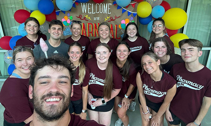 ULM College of Pharmacy Rx Staff group photo in front of welcome banner.