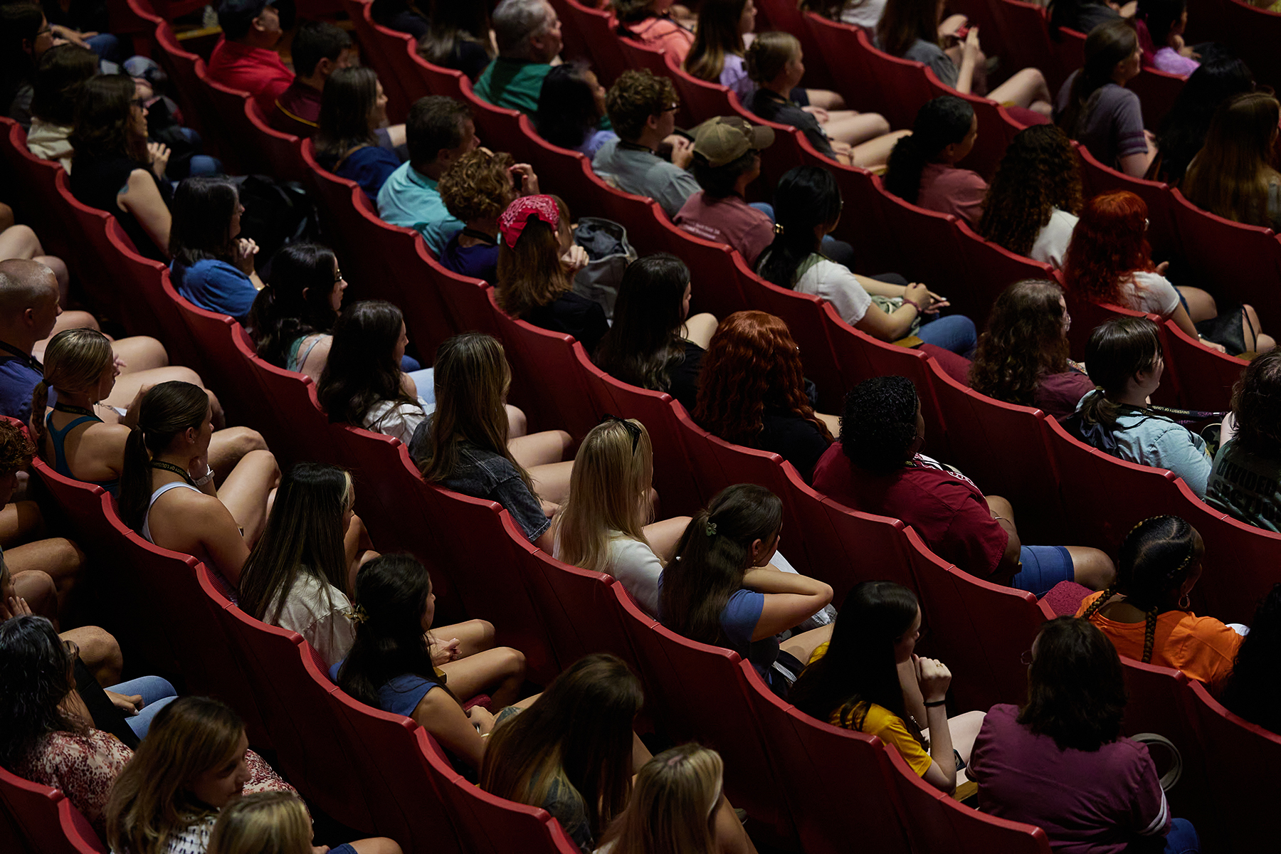 Dozens of people sit in a full theatre