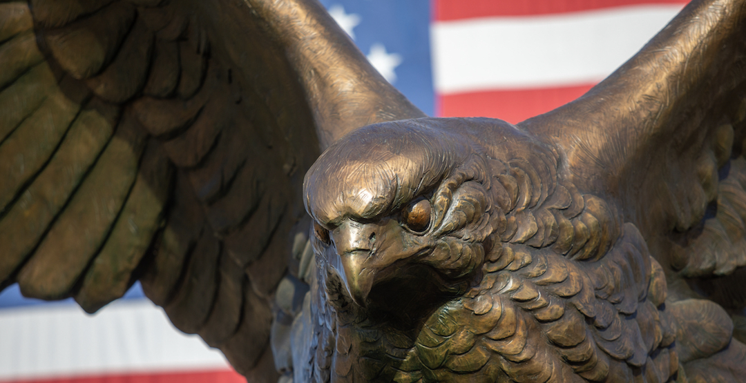 statue of hawk with flag behind